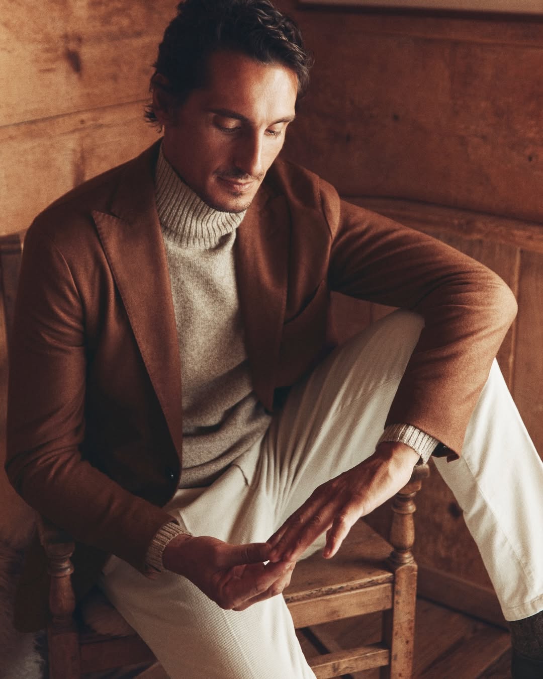man with brown jacket, sweater and beige trousers
